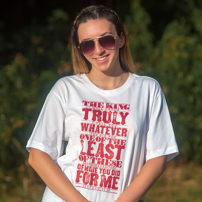 Model wearing Matthew 25:40 in bold, textured design printed in red on white t shirt
