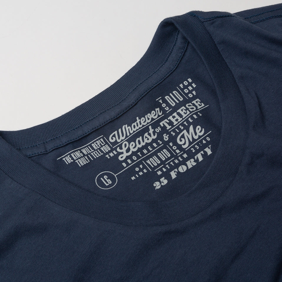 Close up of Matthew 25:40 printed in a modern type design on navy blue t shirt