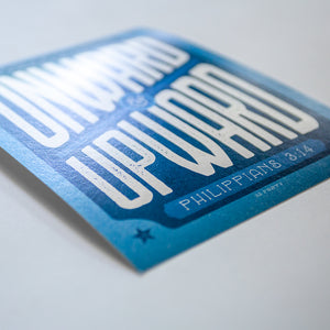 Close up of print with onward and upward and Philippians 3:13 with dynamic blue and white design
