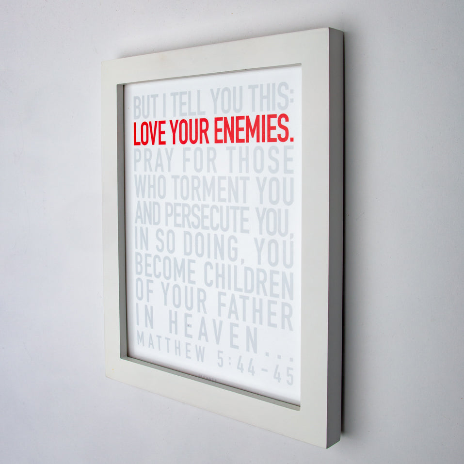 Matthew 5:44-45, Love your enemies in red, other type in gray, on fine art paper in white frame.