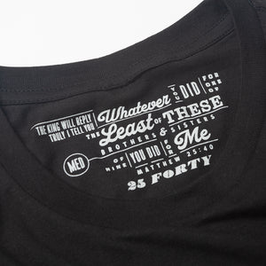 Bible verse Matthew 25:40 printed in light gray as the tag for a black t shirt