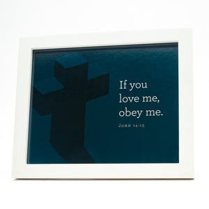 John 14:15, If you love me, obey me. Printed on blue cross background in white frame