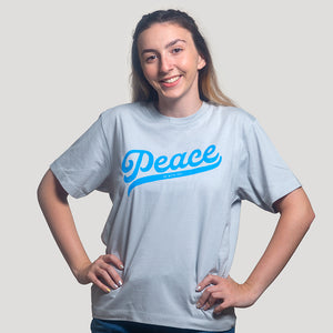 Brunette model wearing light blue Christian t-shirt with "Peace be with you"  in bright blue on the front