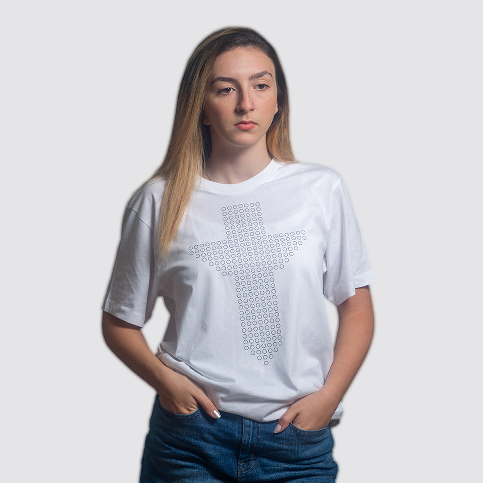 Female model photographed in studio on white background. Model is wearing a white t-shirt with a streetwear style Christian cross consisting of 266 circles with an uplifting vibe.