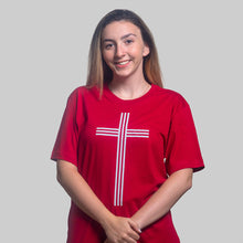 Load image into Gallery viewer, Model wearing red t shirt with white Christian cross shot in studio on white bckground