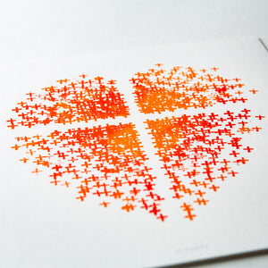 Close up of Orange and red heart made up of crosses with a white cross in the middle on white paper.
