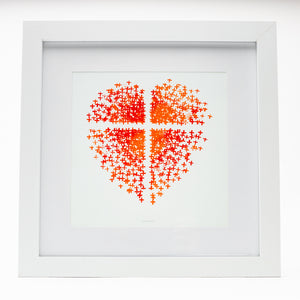 Orange and red heart made up of crosses with a cross in the middle on art paper in white frame